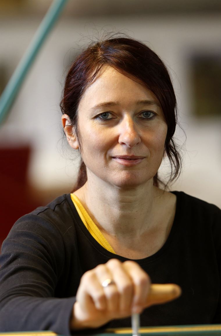 Susanne Merzdorf, Klavier- und Cembalobaumeisterin, in ihrer Werkstatt mit einem Stimmschlüssel an einem Instrument.